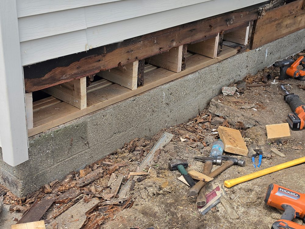 New pressure-treated blocking installed between floor joists after rotted rim joist removal